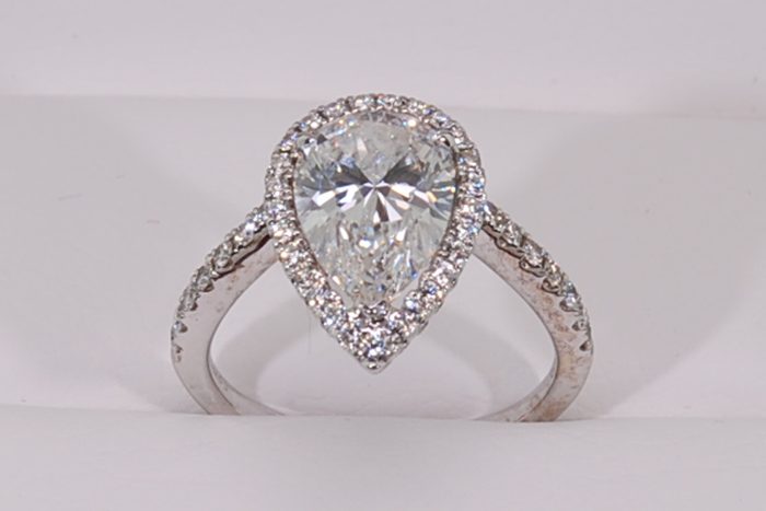Pear-shaped diamond ring with a diamond halo and a diamond-set band