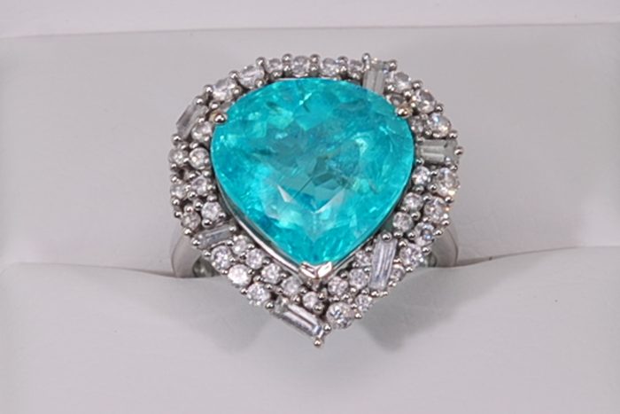 Pear-shaped blue-green gemstone ring with a diamond halo