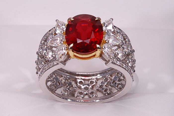 Red gemstone ring with a wide diamond-set band