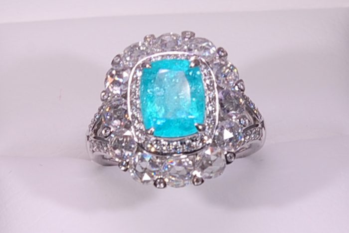 Cushion-cut blue-green gemstone ring with a diamond halo