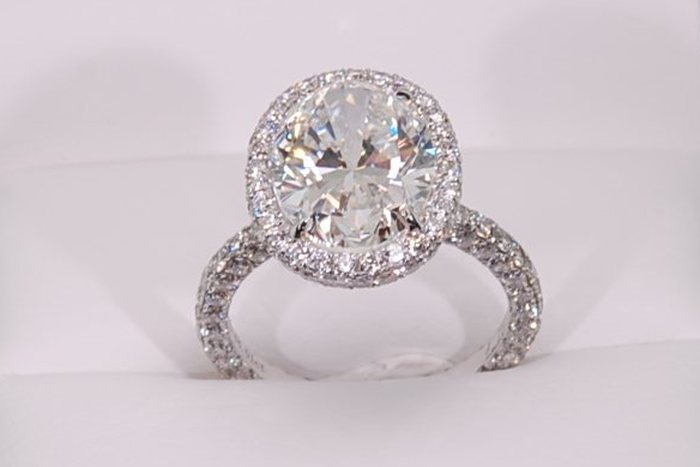 Oval diamond ring with a halo and a diamond-set band