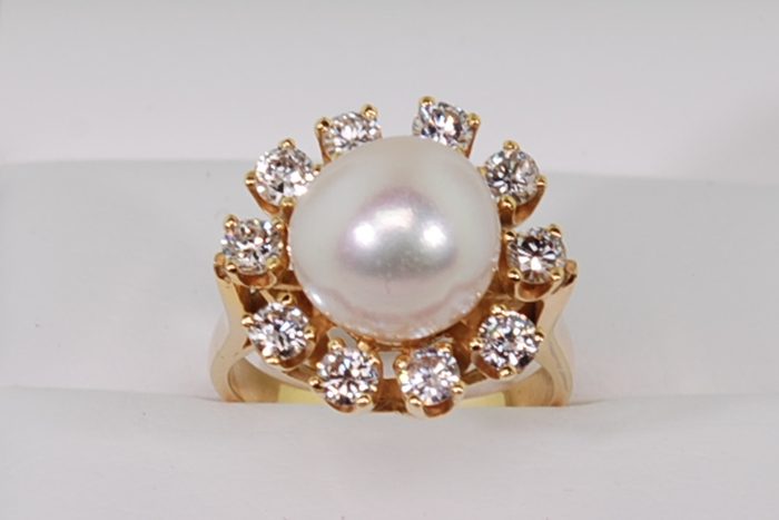 Pearl ring surrounded by diamonds in a yellow gold setting