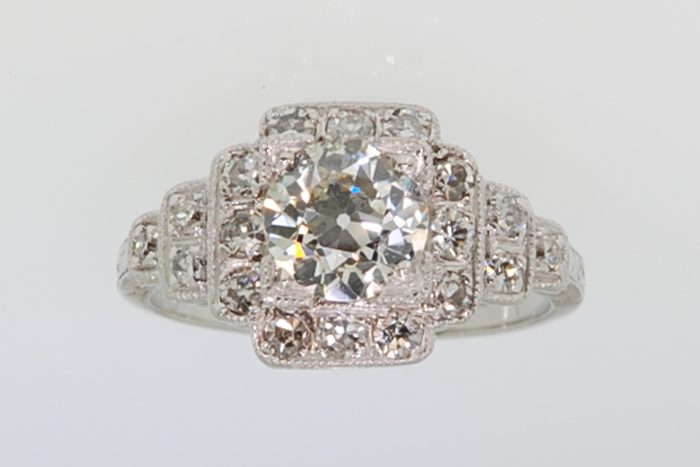 Antique-style platinum diamond ring with a stepped geometric setting