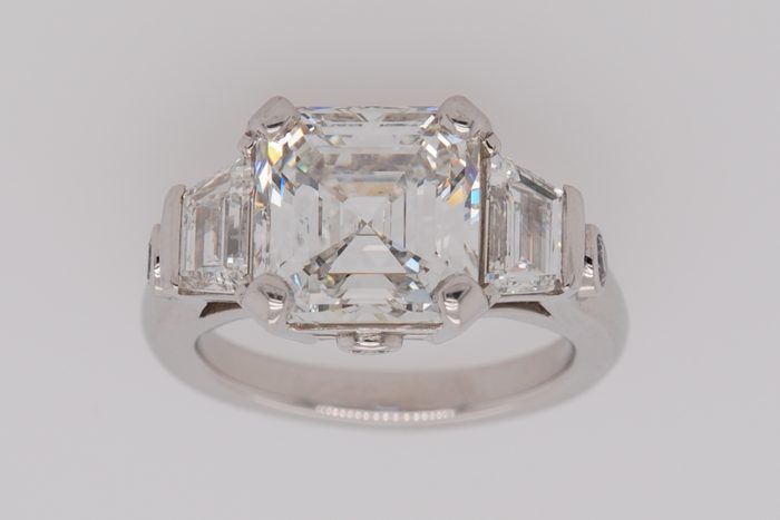 Square step-cut diamond ring with trapezoid side diamonds