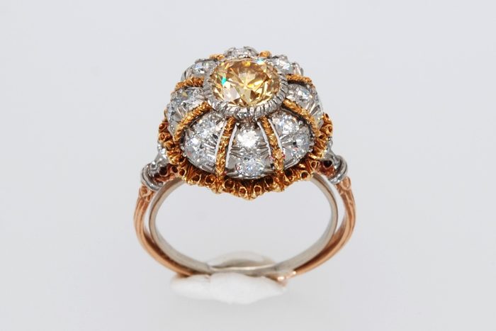 Domed ring with a yellow diamond center, diamonds, and gold detailing