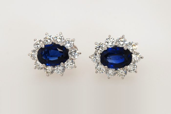 Pair of blue gemstone earrings surrounded by diamonds
