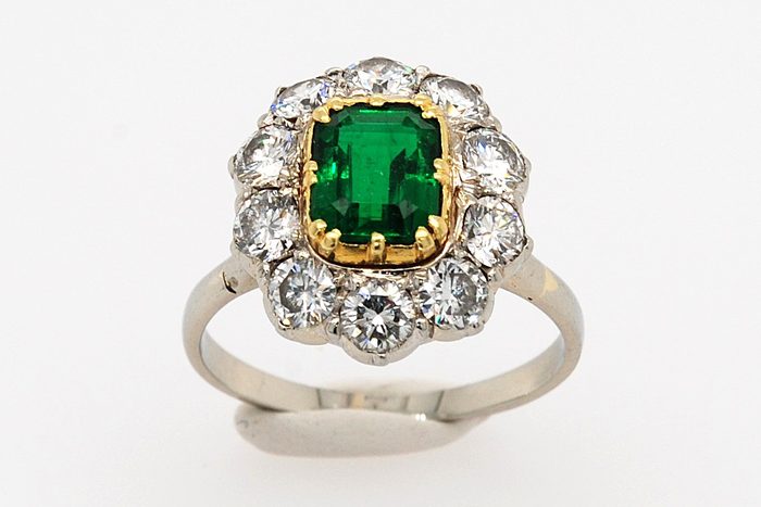 Green gemstone ring with a diamond halo and a white gold band