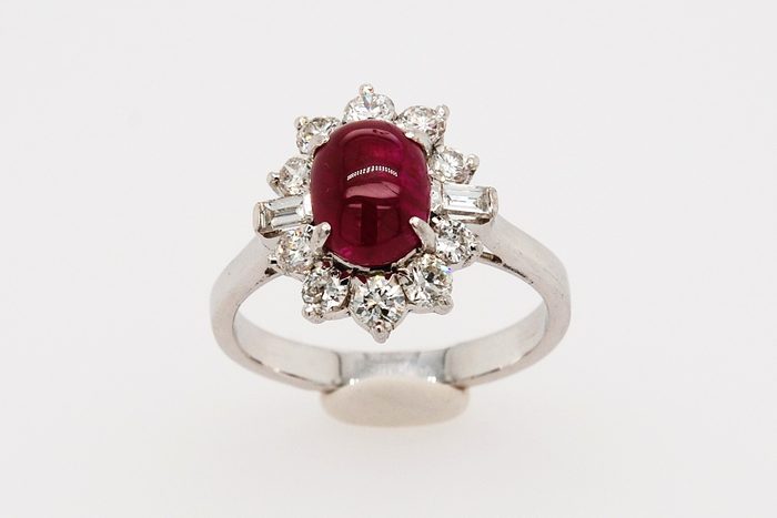Red cabochon gemstone ring with a diamond halo