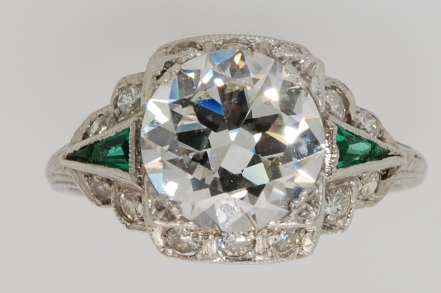 Antique Art Deco platinum ring with a transitional-cut diamond and triangular emeralds