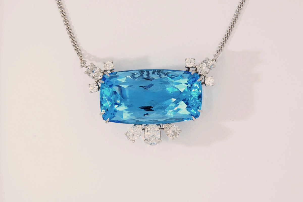Necklace with a large cushion-cut blue gemstone surrounded by diamonds on a white gold chain