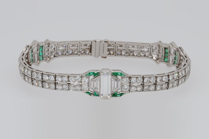 Platinum diamond bracelet with emerald accents