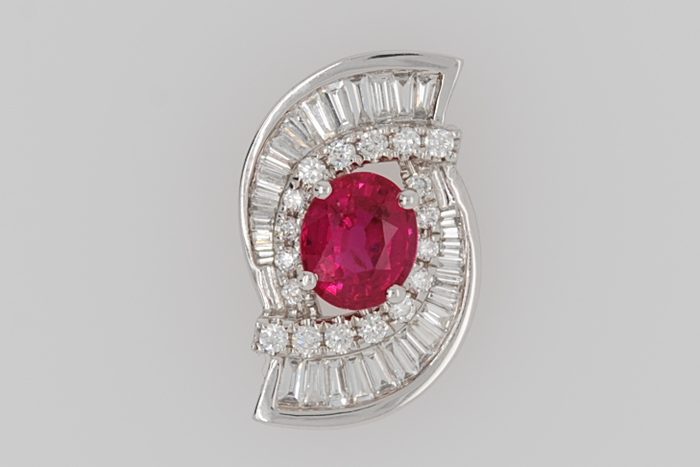 Brooch with a red gemstone and baguette diamonds