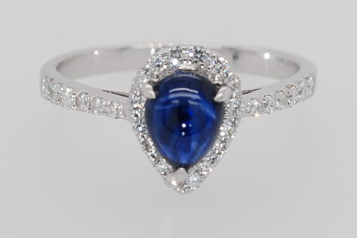 Pear-shaped blue cabochon gemstone ring with diamonds