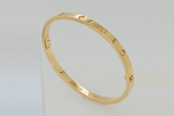 Yellow gold bangle bracelet with screw motifs