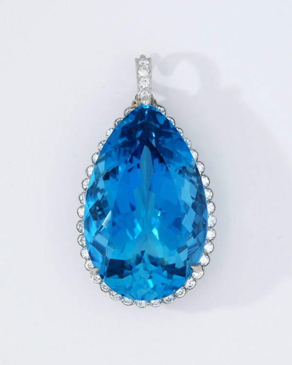 Large pear-shaped blue gemstone pendant surrounded by diamonds