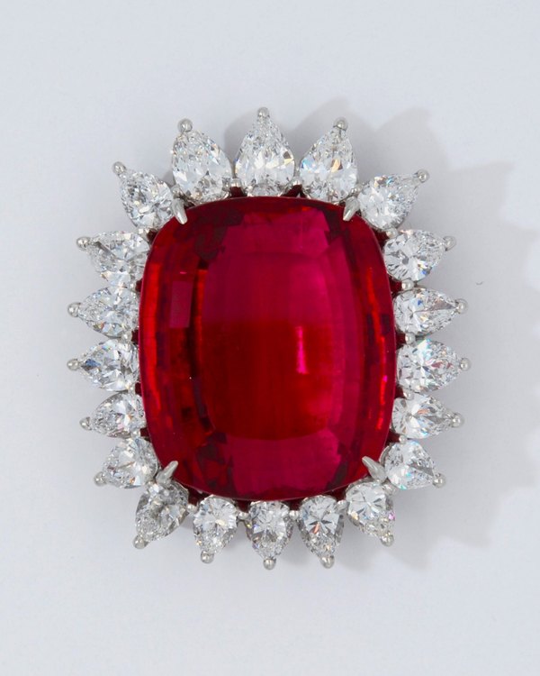 Large cushion-shaped red gemstone brooch surrounded by pear-shaped diamonds