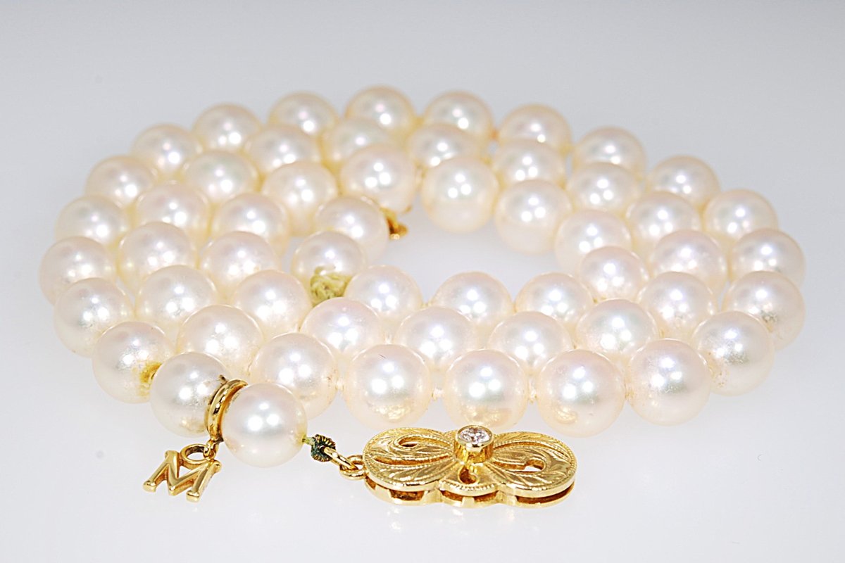 Strand of round cultured pearls with a gold and diamond clasp