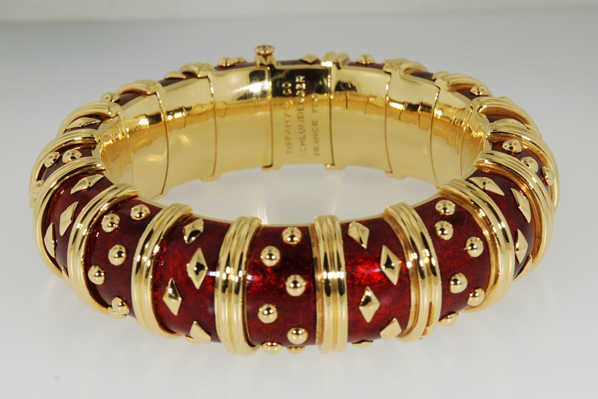 Gold bangle bracelet with red enamel and gold stud accents
