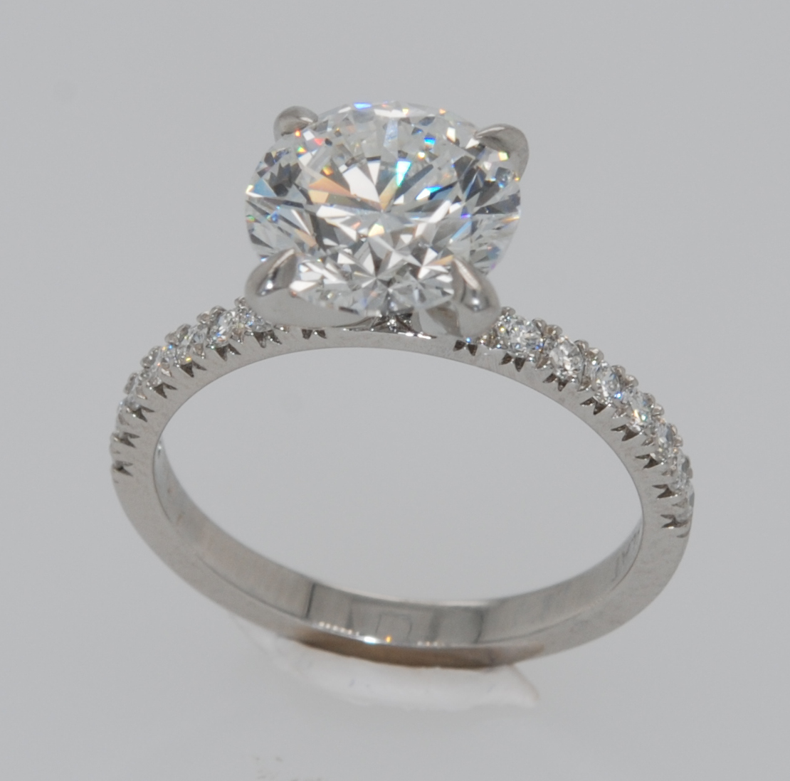 platinum four-prong diamond engagment ring accented with pavé diamonds